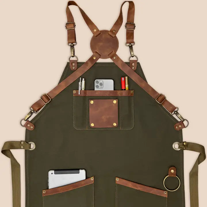High-quality 100% cotton canvas apron with adjustable cross-back genuine leather straps for personalized fit, designed for comfort and durability in kitchens or workshops.