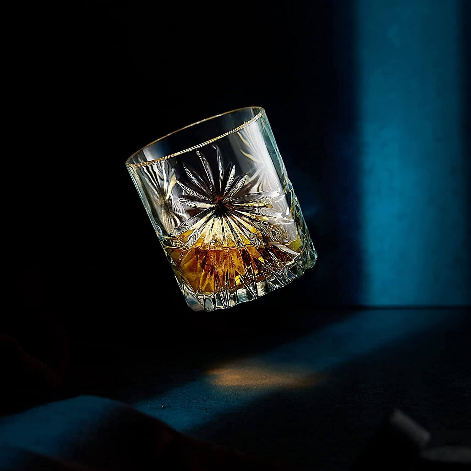 Soleil glass whiskey tumbler showcasing amber liquid, perfect for whiskey chilling stones and elegant barware.