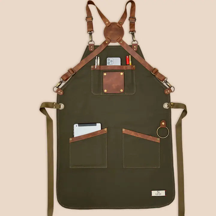 High-quality 100% cotton canvas apron with adjustable cross-back genuine leather straps for personalized fit, designed for comfort and durability in kitchens or workshops.