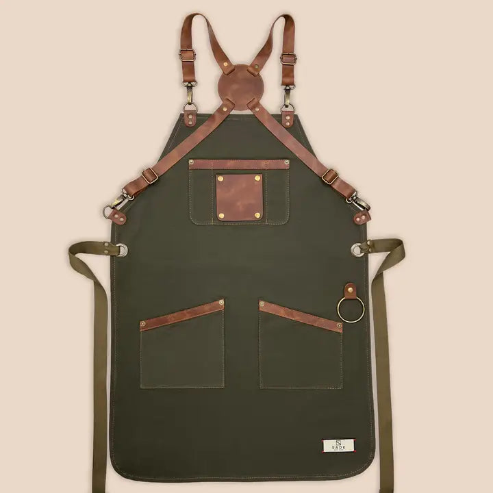High-quality 100% cotton canvas apron with adjustable cross-back genuine leather straps for personalized fit, designed for comfort and durability in kitchens or workshops.