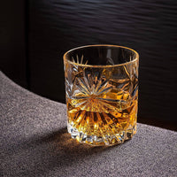 Elegant Soleil crystal whiskey glass filled with amber whiskey on a textured surface, ideal for connoisseurs.