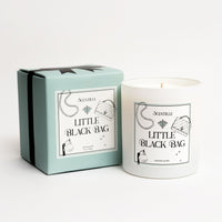 Candle labeled 'Little Black Bag' with packaging on a white background