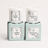 Two candles named 'Midnight Rose' and 'Garden Party' in their packaging on a white background.