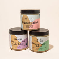Three jars of tahini stacked in a pyramid.